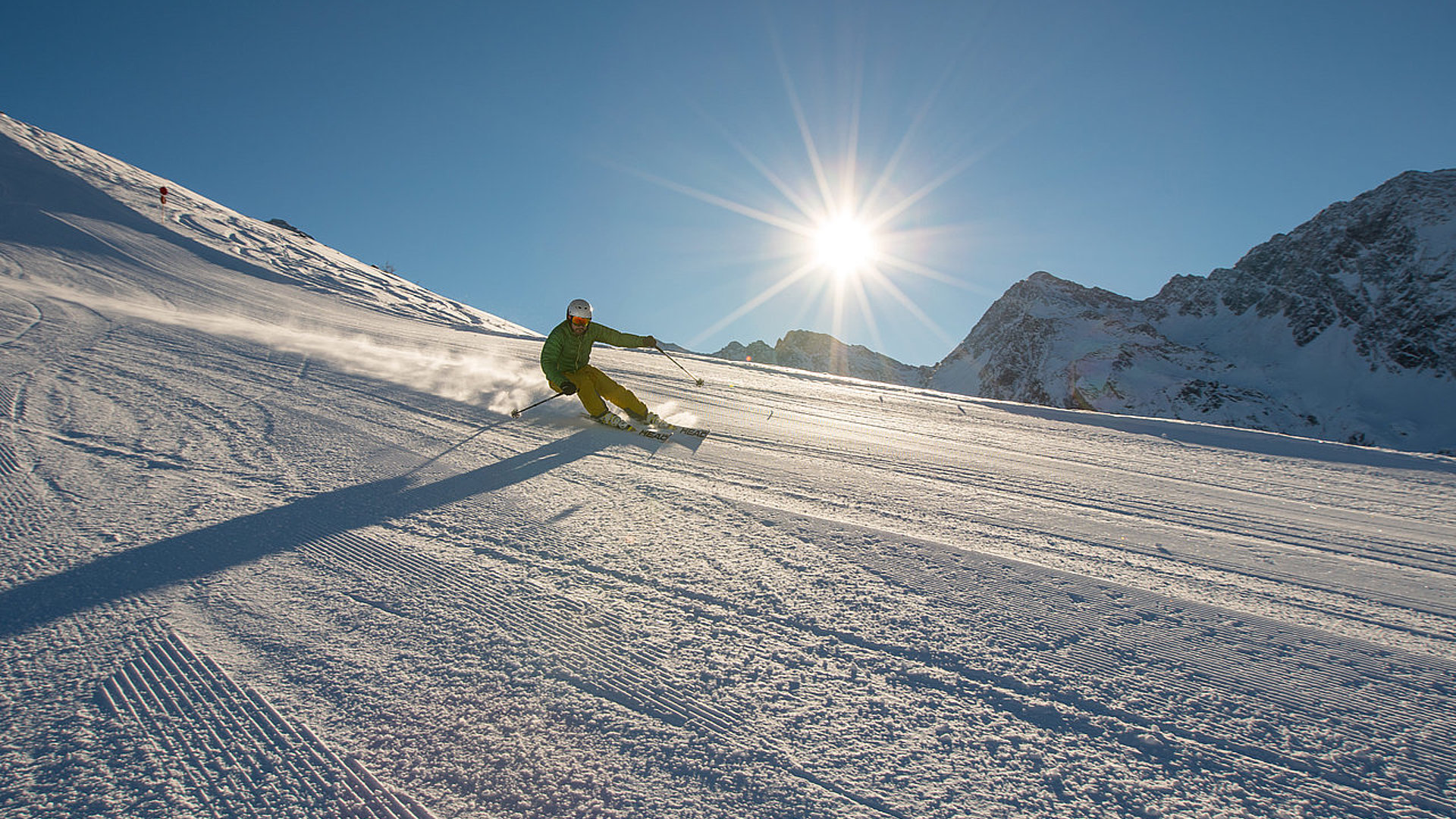 Skifahrer bei Sonnenschein auf frisch präparierter Piste